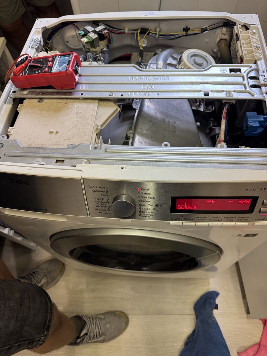 Diagnosi elettrica su una lavatrice aperta